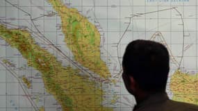 Un membre de l'armée de l'air indonésienne étudie une carte des zones visées par les recherches, le 12 mars.