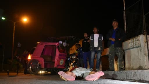 Des villageois observent un corps à Quezon City, près de Manille, aux Philippines, le 9 mars 2017 alors que bat son plein la guerre contre la drogue Des villageois observent un corps à Quezon City, près de Manille, aux Philippines, le 9 mars 2017 alors que bat son plein la guerre contre la drogue