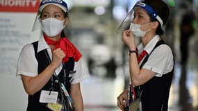 Des hôtesses portent des masques et des visières de protection à l'aéroport de Narita, le 19 août 2020 au Japon (Photo d'illustration)