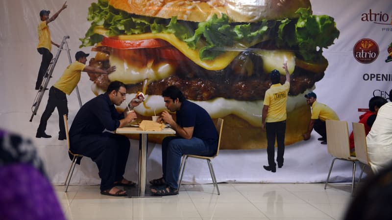 Deux hommes mangeant un burger.