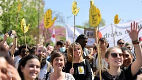 Manifestants brandissant des pancartes "Touche pas à mon pote",  lors d'un rassemblement à Paris le 16 avril 2022 pour dénoncer l'extrême droite.