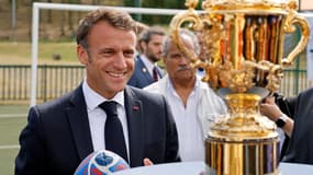 Emmanuel Macron posant devant la Coupe du monde de rugby