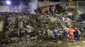 Des secouristes à la recherche de survivants dans les décombres d'un bâtiment effondré