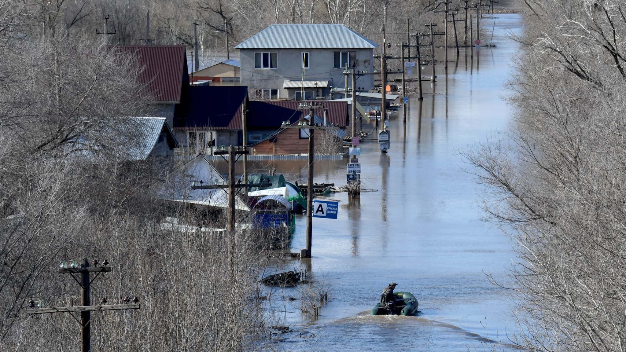 Un habitant navigue sur un bateau en caoutchouc dans une zone résidentielle inondée de la ville d'Orenburg, le 13 avril 2024.
