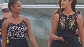 Sasha et Malia, filles de Barack Obama, s'apprêtant à embarquer à bord de Air Force One, le 30 août 2014.