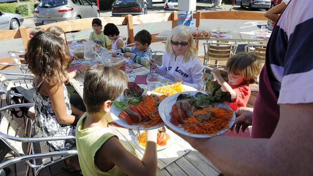 Des enfants déjeunent le 12 septembre 2011 dans un restaurant du centre-ville de Thonon-les-Bains, invités par des commerçants "outrés" par la décision du maire de restreindre l'accès à la cantine des enfants de chômeurs.