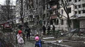 Des enfants devant un appartement détruit par un bombardement à Obolon, dans la banlieue de Kiev ce lundi 14 mars.