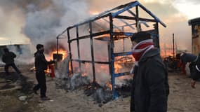Un migrant tente vainement d'éteindre un incendie lors du démantèlement de la "jungle" de Calais, lundi 29 février.
