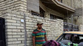 Une voiture endommagée sur le site de l'attentat suicide revendiqué par l'EI et qui visait les musulmans chiites le 15 octobre 2016, dans un quartier de Bagdad.