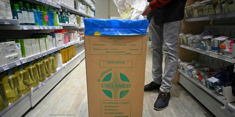 Un homme jette des médicaments non utilisés dans une boîte en carton de l'organisme Cyclamed, chargé de leur collecte, le 23 mars 2023 dans une pharmacie à Colomiers (Nord). (Illustration)