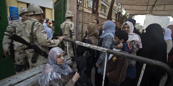 Des forces de sécurité égyptiennes déployées mardi matin devant un bureau de vote du Caire.