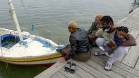 Des migrants africains devant un bateau de pêche dans la ville côtière de Sfax en Tunisie, le 22 avril 2021