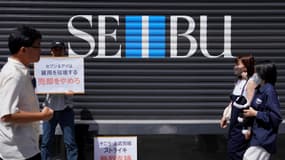 Un employé du grand magasin Seibu en grève devant l'enseigne, à Tokyo.