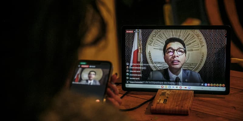 Une habitante d'Antananarivo regarde le discours du président malgache Andry Rajoelina à la nation via la page Facebook officielle de la présidence de Madagascar, depuis son domicile à Antananarivo, le 13 octobre 2025.