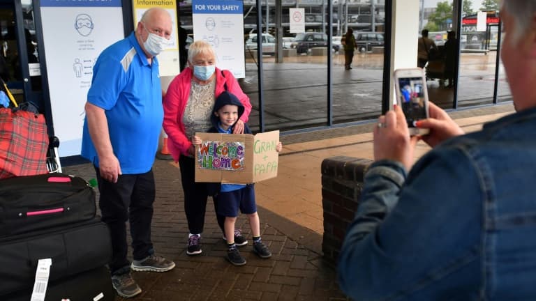 Un enfant accueille ses grands-parents de retour de Nouvelle-Zélande à l'aéroport de Manchester, dans le nord-ouest de l'Angleterre, le 31 juillet 2020