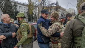 Soldats Ukrainiens et civils à la rencontre les uns des autres à Kherson le 14 novembre 2022. 