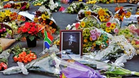 Un portrait de Nelson Mandela entouré de fleurs déposées par des anonymes à Johannesburg, le 6 décembre 2013.ed icon of the anti-apartheid struggle in South Africa and o