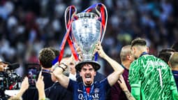 Le Portugais Vitinha en train de célébrer la victoire du PSG en Ligue des champions avec le trophée sur la tête, le 31 mai 2025