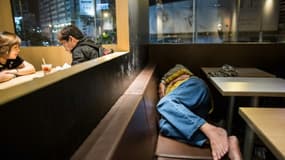 Un SDF dort dans un restaurant McDonald, dans le quartier Kwoolon à Hong Kong, le 8 avril 2016