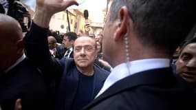 Silvio Berlusconi, entouré de gardes du corps,  salue ses supporteurs, le 11 mars 2015 à Rome
