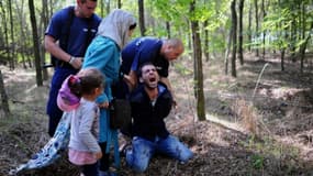 Le père d'une famille de migrants est arrêté par la police locale près du village de Röszke, en Hongrie, à la frontière avec la Serbie le 28 août 2015