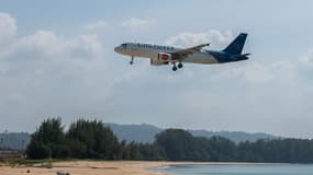 Un Airbus A320 de Thai AirAsia survolant une plage vide lors de son atterrissage à l'aéroport international de Phuket, à Phuket.