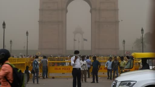 Un policier dirige le trafic automobile à New Delhi le 2 mai 2018 en pleine tempête de sable.