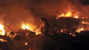 Un manifestant alimente les barricades enflammées en pneus, le 19 février, place de l'Indépendance, à Kiev.