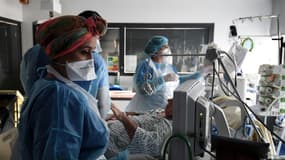 Des soignants s'occupent d'un patient atteint du Covid-19 dans l'unité de soins intensifs de l'hôpital Tenon, le 26 janvier 2021 à Paris
