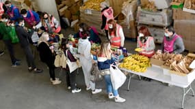 Des bénévoles des Restos du coeur distribuent des produits alimentaires à des étudiants le 26 mars 2021 au Vélodrome de Marseille
