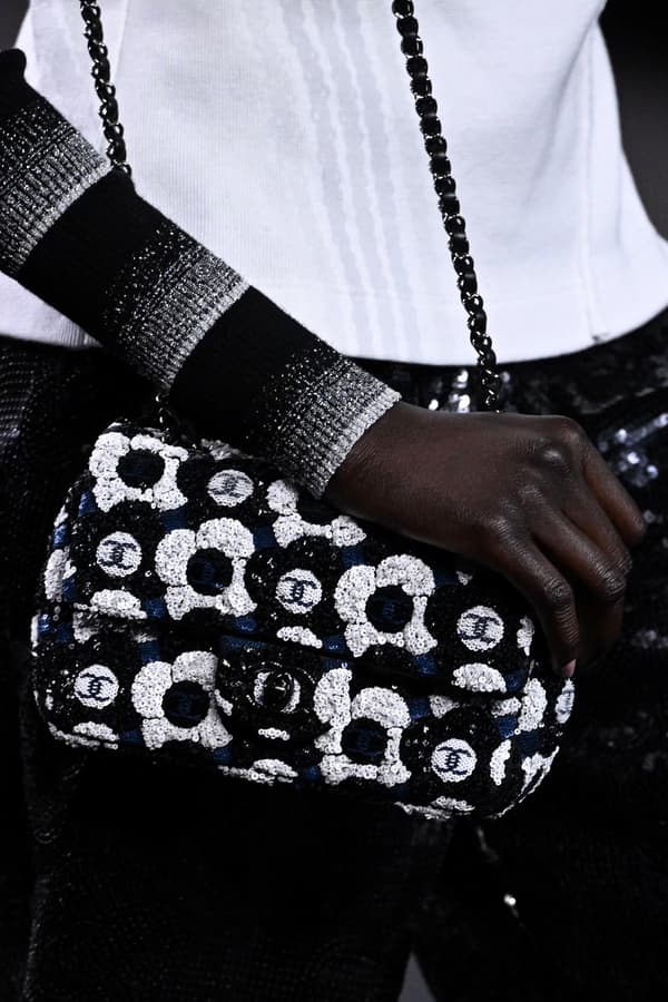 Le camélia sur tous les accessoires, bijoux, en motif, lors du défilé automne-hiver 2023 de Chanel à Paris.