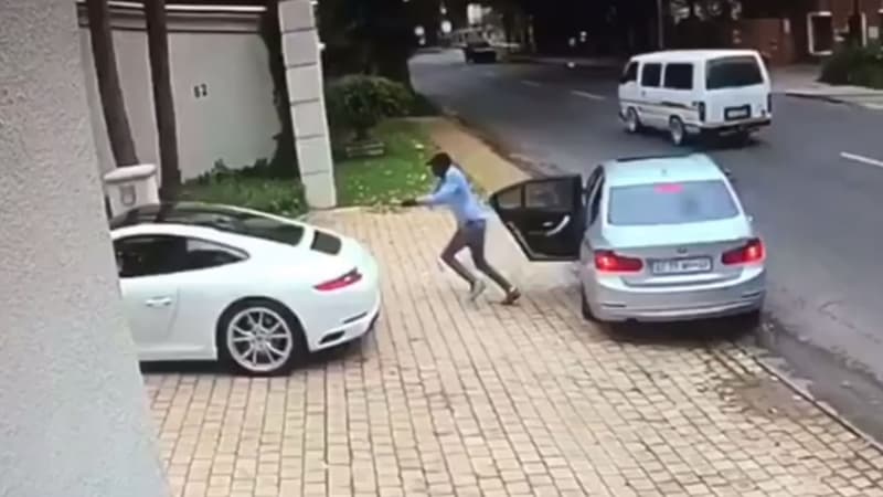 L'agresseur vient de sortir d'une BMW et s'apprête à braquer son arme sur le propriétaire de cette Porsche.