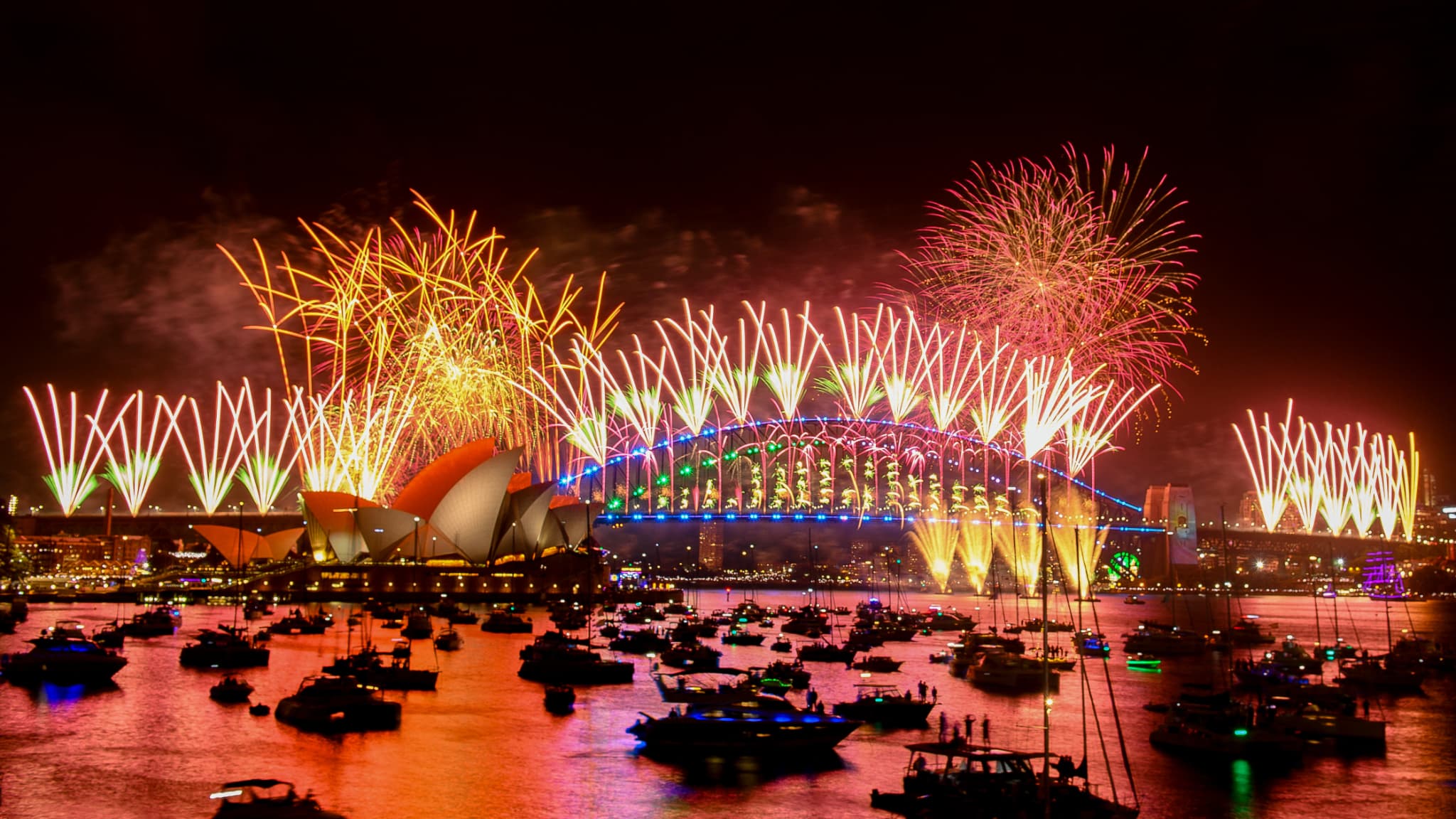 Des feux d'artifice explosent au-dessus du pont du port de Sydney et de l'opéra de Sydney (à gauche) lors des célébrations du Nouvel An à Sydney, le 1er janvier 2024.