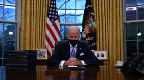 Le président Joe Biden signe ses premiers décrets dans le Bureau ovale de la Maison Blanche, le 20 janvier 2021