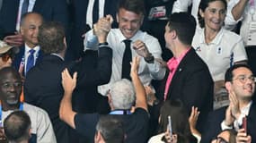 Emmanuel Macron (C) dans les tribunes après la victoire du nageur français Léon Marchand au 200 m 4 nages, le 2 août 2024 à La Defense Arena