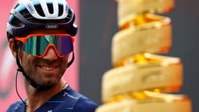 Le coureur espagnol de l'équipe Movistar, Alejandro Valverde, regarde le trophée du vainqueur de la course "Trofeo Senza Fine" pendant la présentation des équipes avant le départ de la 15ème étape du Giro 2022, le 22 mai 2022.
