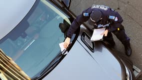 Un policier municipal dresse un procès-verbal de stationnement. (image d'illustration) 