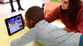 Un enfant devant une tablette (illustration)