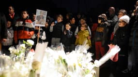 Des enfants et leurs parents rendent hommage au directeur assassiné, la semaine dernière.