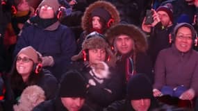 Des spectateurs tiennent leur chien lors d'un concert pour chiens à Times Square à New York le 4 janvier 2016