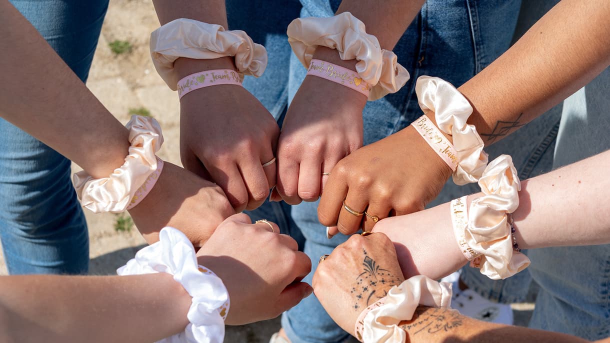 Les poignets de participantes à un enterrement de vie de jeune fille, affublés de bracelets et de chouchous assortis.