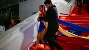 Une femme vêtue d'une robe aux couleurs du drapeau de l'Ukraine a fait irruption sur le tapis rouge du Festival de Cannes pour s'y recouvrir de faux sang.
