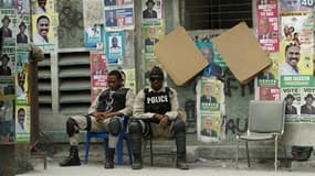 Des policiers montent la garde à Port-au-Prince. Entre séisme, cyclone et choléra, Haïti attend avec fébrilité la publication, ce mardi, des résultats préliminaires du premier tour de l'élection présidentielle du 28 novembre, où 18 candidats s'étaient pré