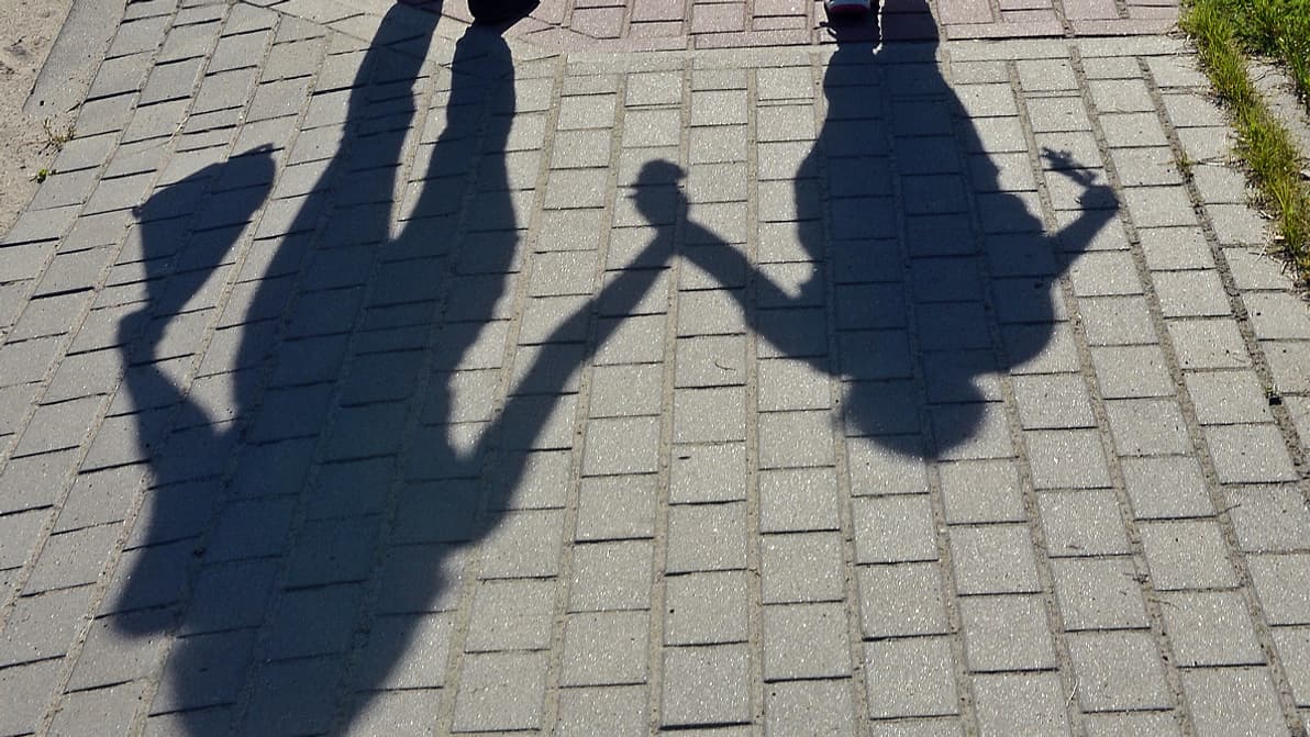 L'ombre d'une femme tenant son enfant par la main (photo d'illustration). L'ombre d'une femme tenant son enfant par la main (photo d'illustration).