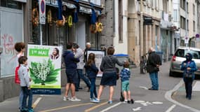 Des clients attendent devant un magasin de fleurs pour acheter du muguet, le 1er mai 2020 à Strasbourg