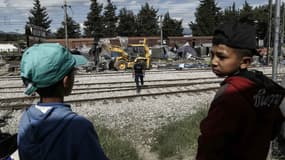 Deux enfants voient se dérouler devant leurs yeux l'opération de police visant à évacuer le camp d'Idomenie, le 25 mai 2016. 