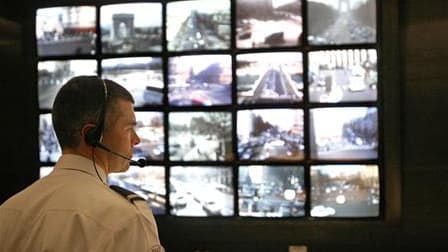 Ecrans de surveillance à la préfecture de Paris. Environ 25.000 caméras vont être installées dans les trains et les gares français dans le cadre d'un plan de sécurisation, annonce Brice Hortefeux. /Photo d'archives/REUTERS/Charles Platiau