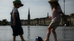 Des enfants se rafraîchissent à Bordeaux en plein record de chaleur pour un printemps en France, le 18 mai 2022