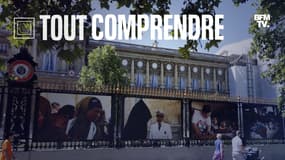 Des passants marchent devant des photographies de Frédéric de La Mure, exposées sur la façade du Quai d'Orsay le 23 juillet 2012 à Paris. 