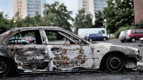 Carcasse d'une voiture incendiée au lendemain des émeutes, le 15 août 2012, dans les quartiers nord d'Amiens